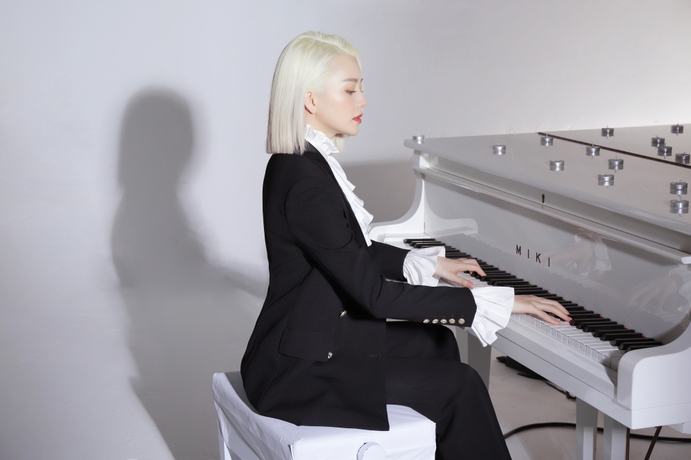  
Cô gái cá tính ngồi trên chiếc đàn piano.