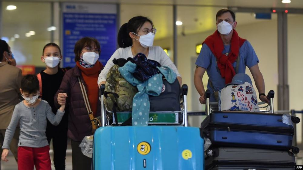  
Hành khách từ nước ngoài trở về được kiểm tra y tế và cách ly 14 ngày (Ảnh: VOA)