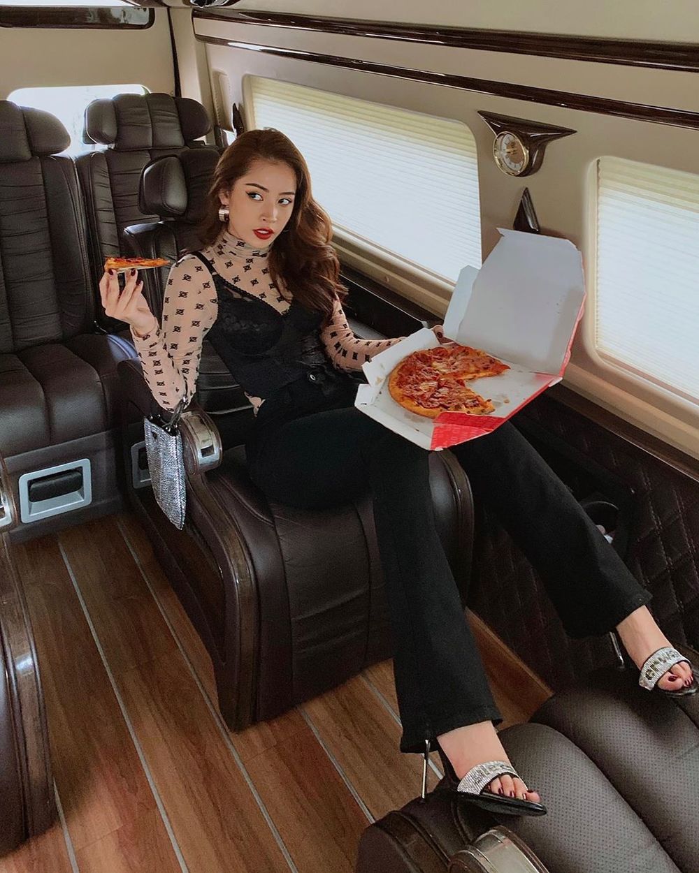  
Chi Pu lại sáng tạo hơn khi chụp ảnh trong xe, người đẹp diện bộ cánh hiệu, tạo dáng đang ăn pizza. (Ảnh: FBNV)
