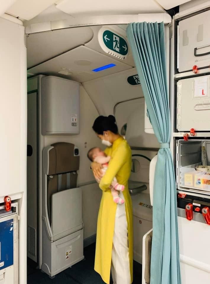  
Nữ tiếp viên hàng không dỗ dành em bé 2 tháng tuổi khóc vì nhớ mẹ. (Ảnh: Nguyên Lê)