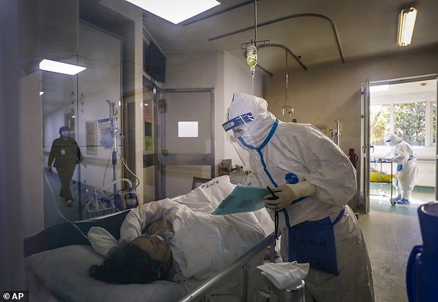  
Nhân viên y tế tiến hành thăm khám cho bệnh nhân nhiễm Covid-19. (Ảnh: AP).