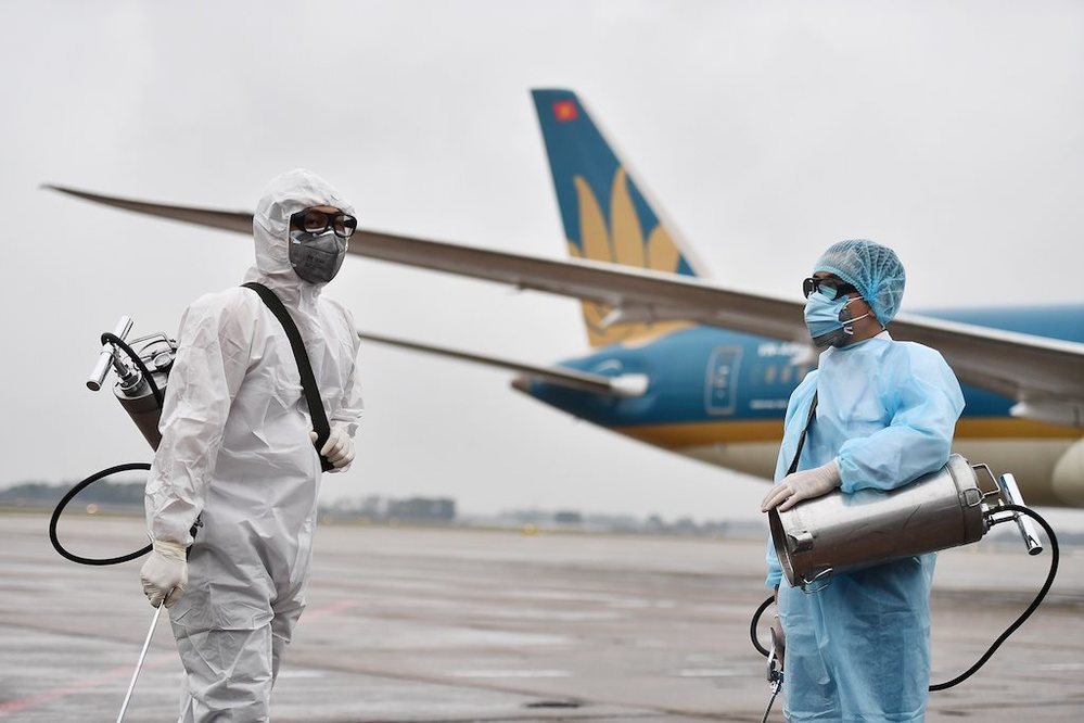  
Đội ngũ y tế tiến hành khử trùng máy bay (Ảnh: VNA)