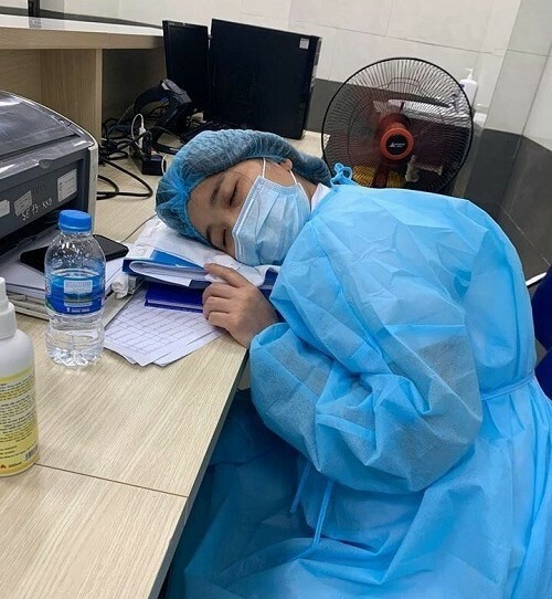  
Gối đầu lên chồng tài liệu dày, nữ nhân viên y tế ngủ gục sau ca trực dài. (Ảnh: Bệnh viện Bạch Mai)