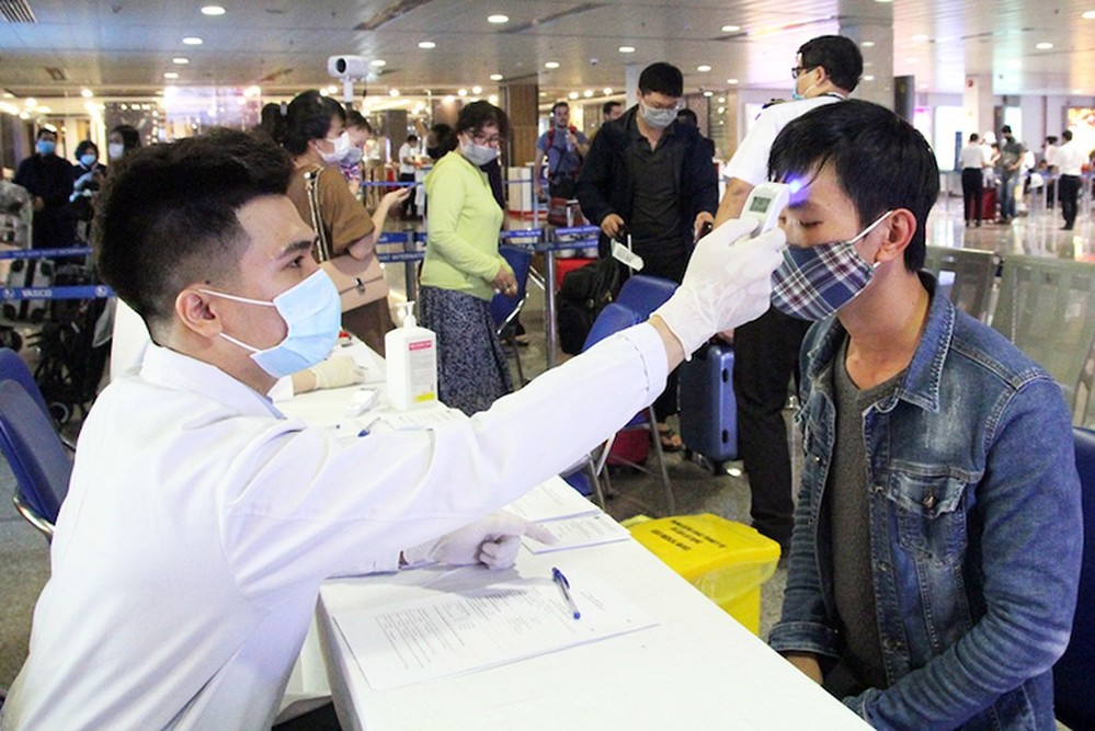  
Nhân viên y tế tiến hành đo thân nhiệt cho các hành khách tại sân bay (Ảnh: Net News)