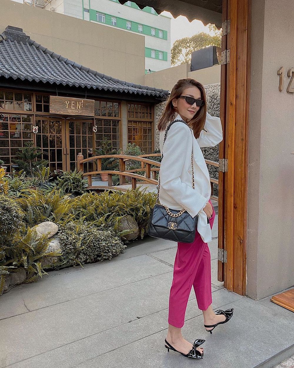  
Thanh Hằng phá cách với bộ cánh hơi hướng công sở, cô chọn quần vải màu hồng tím, blazer lụa trắng và đeo túi xách Chanel. (Ảnh: Instagram nhân vật)