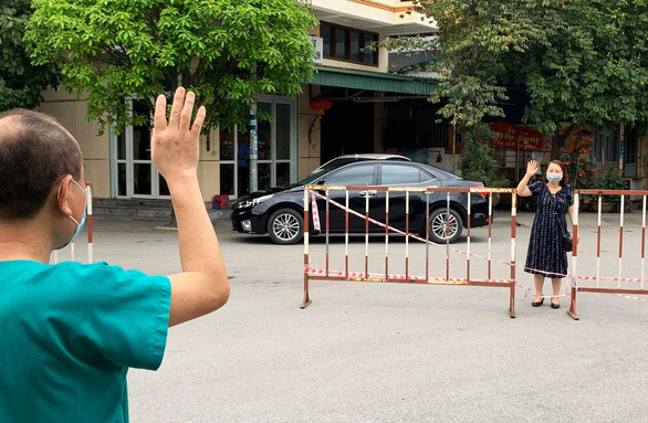  
Vợ thăm chồng là giám đốc bệnh viện qua hàng rào cách ly​. (Ảnh: Bệnh Viện Sản Nhi Quảng Ninh).
