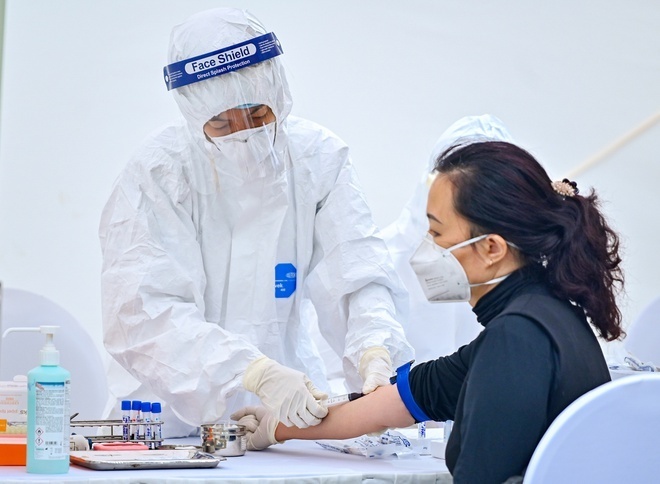  
Nhân viên y tế tiến hành kiểm tra sức khỏe cho người từng tới bệnh viện Bạch Mai. (Ảnh: Zing)