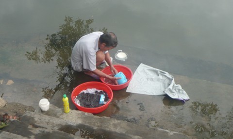  
Người đàn ông làng Công Lương ra ao rửa bát, giặt đồ giúp vợ (Ảnh: Tiền Phong)