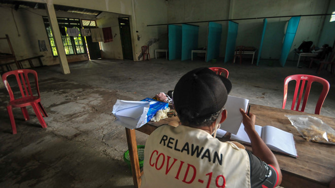  
Hình ảnh một nhân viên tình nguyện đang ngồi canh gác tại ngôi nhà bỏ hoang. (Ảnh: AFP)
