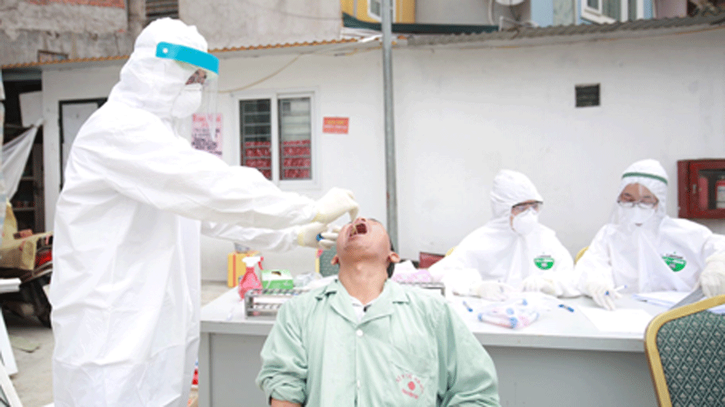  
Nhân viên y tế lấy mẫu xét nghiệm sàng lọc Covid-19 tại ổ dịch thôn Hạ Lôi (Hà Nội). (Ảnh: Thanh Niên)