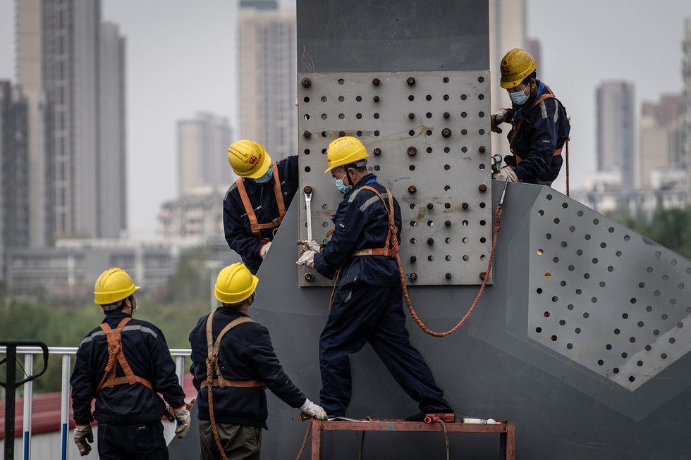  
Những người công nhân đã bắt đầu làm việc lại ở Vũ Hán. (Ảnh: Reuters)