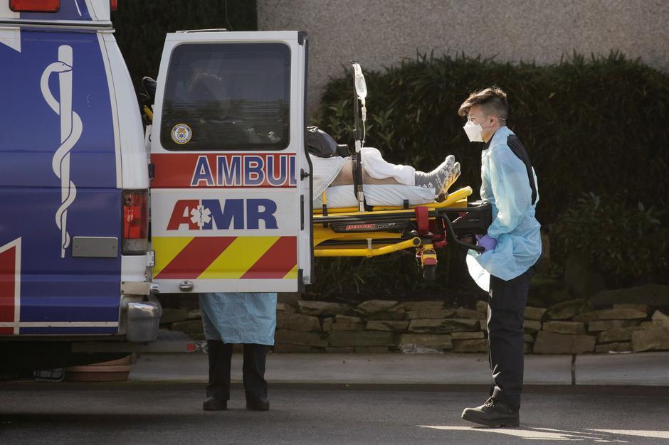  
Các nhân viên y tế đang tiến hành đưa bệnh nhân nhiễm Covid-19 đến bệnh viện. (Ảnh: Reuters)