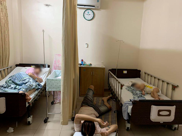  
Cả gia đình nhỏ cùng nhau ngủ trong bệnh viện. Anh chồng còn nằm dưới đất để nhường giường cho vợ con. (Ảnh: FB N.T.P.L)