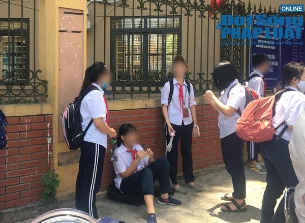  
Các em học sinh tìm bóng râm tại khu vực bờ tường trường học để chờ bố mẹ đến đón (Ảnh: Đời sống & Pháp luật)