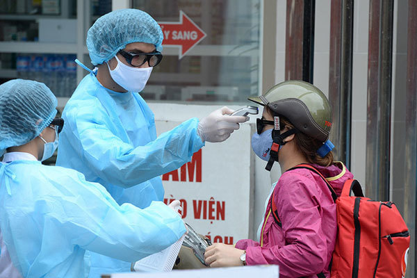  
Nhân viên y tế kiểm tra thân nhiệt cho người dân tại nơi công cộng (Ảnh: 2sao)