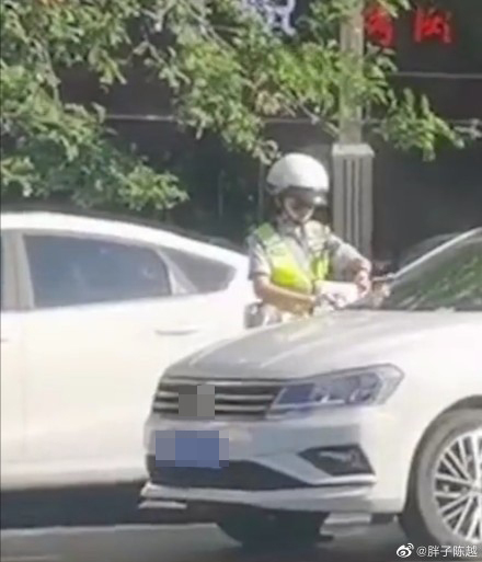  
Nữ cảnh sát đang kẹp vé phạt lên xe. (Ảnh: Weibo)