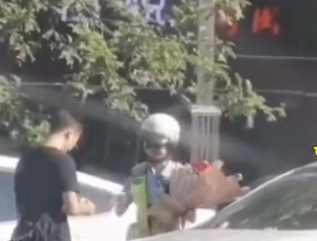  
Nữ cảnh sát vẫn nhận lấy bó hoa từ chồng và không hủy vé phạt. (Ảnh: Weibo)