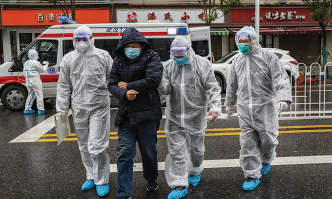 Bệnh nhân nhiễm nCoV được nhân viên y tế đưa đến bệnh viện ở TP. Vũ Hán (Trung Quốc) (Ảnh: AFP)