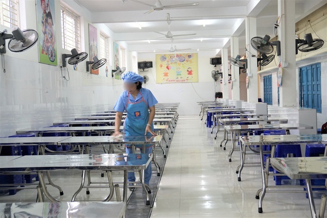  
Nhân viên nhà ăn của 1 trường tiểu học lau dọn khu vực bàn ghế để đảm bảo an toàn cho học sinh bán trú (Ảnh: Báo Gia đình)