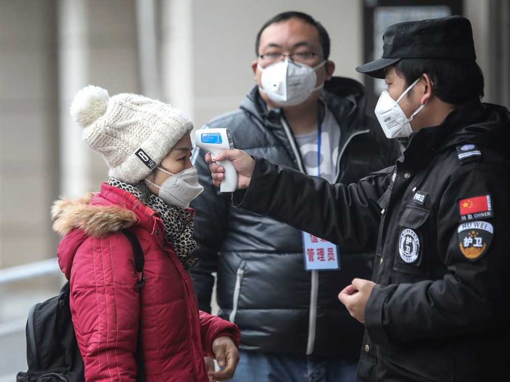  
Nhân viên tiến hành kiểm tra thân nhiệt cho mọi người (Ảnh: Reuters)