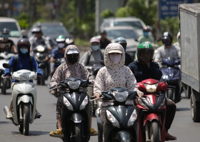  
Những người đi xe máy bịt kín mít khi di chuyển (Ảnh: Dân Trí)