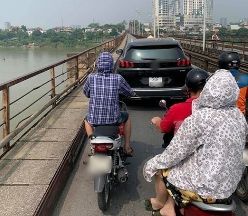 
Hàng dài xe máy phải nhích từng chút một sau chiếc ô tô trên cầu Long Biên (Ảnh: Nguyễn Linh)