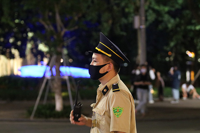  
Lực lượng trật tự túc trực để nhắc nhở mọi người đeo khẩu trang (Ảnh: Tuổi trẻ Online)