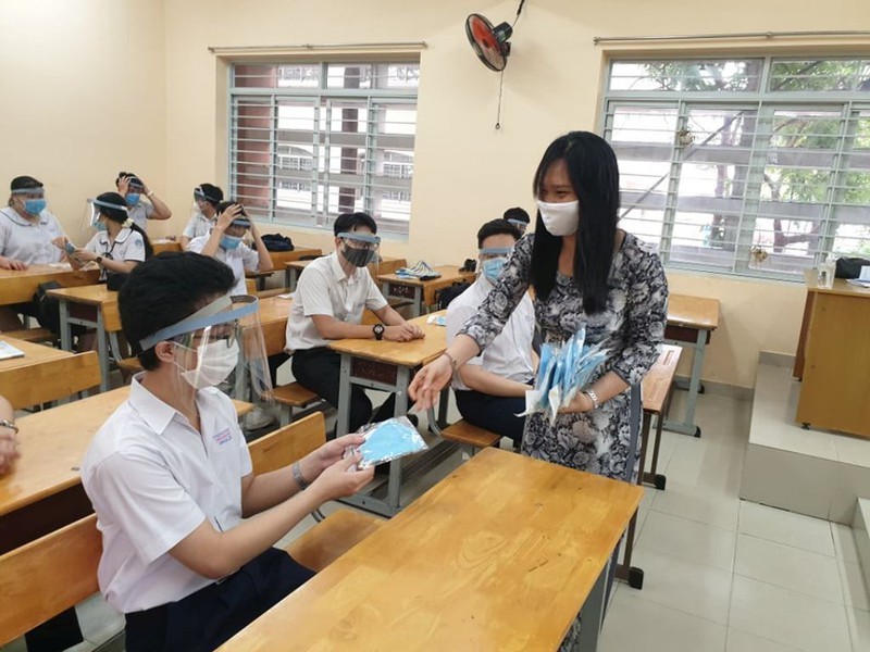  Học sinh đeo cả khẩu trang và nón chống giọt bắn khi đến lớp (Ảnh: Pháp luật online)