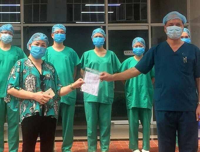 Bệnh nhân 312 nhận giấy chứng nhận khỏi Covid-19 từ bác sĩ (Ảnh: VnExpress)