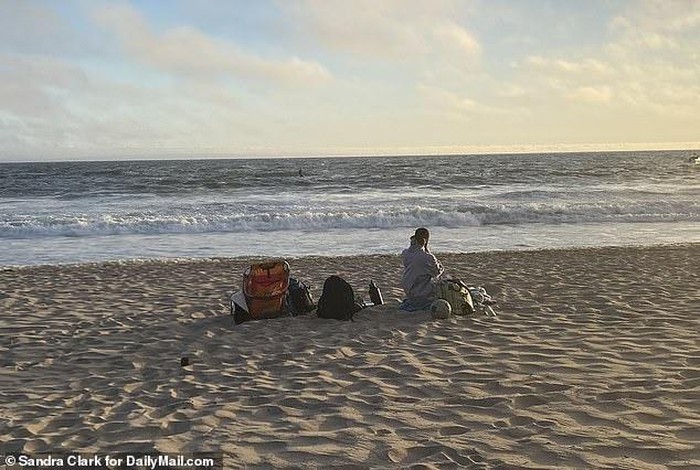 
Vợ của cựu đô vật ngồi đợi tin chồng bên bờ biển (Ảnh: Sandra Clark/DailyMail)