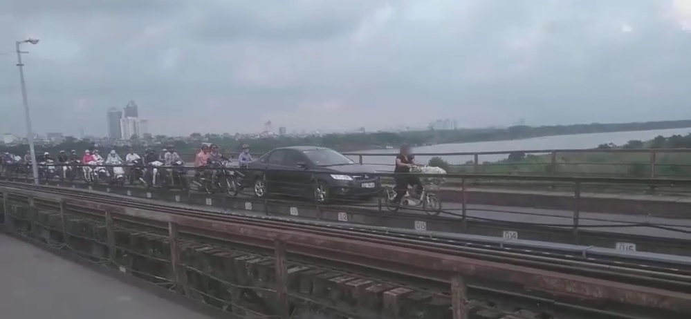  
Chiếc xe ô tô đi với tốc độ xe đạp trên cầu Long Biên (Ảnh: Chụp màn hình)