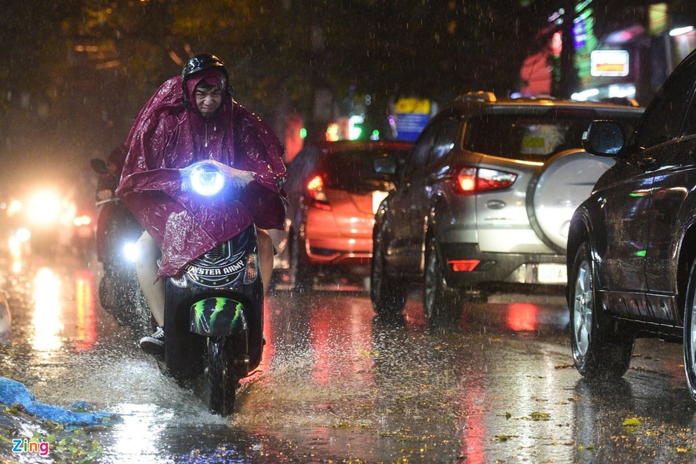  
Mọi người di chuyển trong cơn mưa buổi chiều tối ở Hà Nội (Ảnh: Zing)
