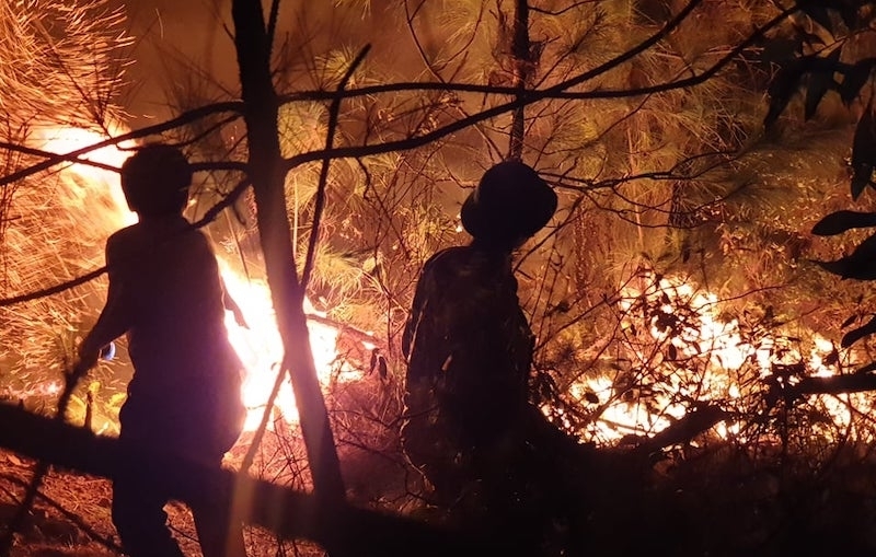  
Các chiến sĩ tham gia dập tắt đám cháy ở Diễn An. (Ảnh: Lao Động). 