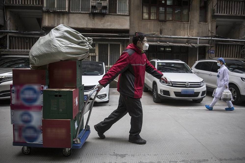 Một nhân viên đẩy xe hàng hóa cho bệnh viện ở Vũ Hán (Ảnh: Chinadaily)