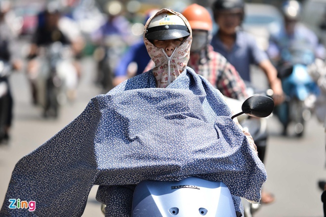  
Người dân tận dụng những vật sẵn có để che kín khi ra đường trong thời tiết nắng nóng (Ảnh: Zing.vn)