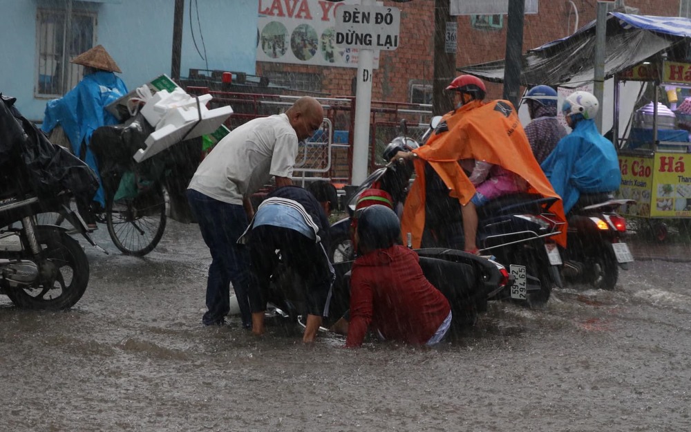  
Người đi đường bị ngã nhào khi di chuyển trong mưa (Ảnh: Tuổi Trẻ Online)