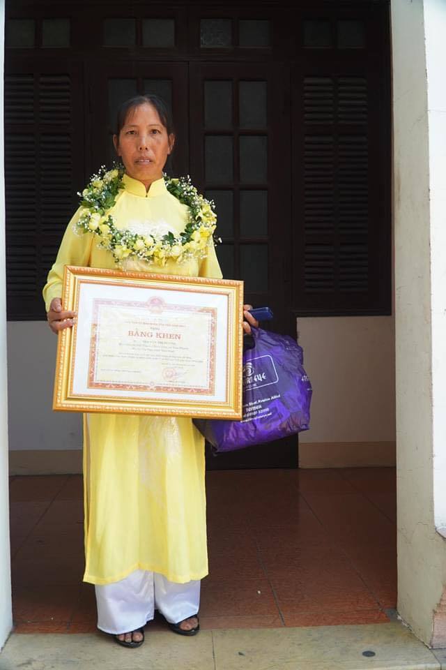  
Cô Hương trong bộ áo dài vàng lên nhận bằng khen (Nguồn ảnh: phunuvietnam)