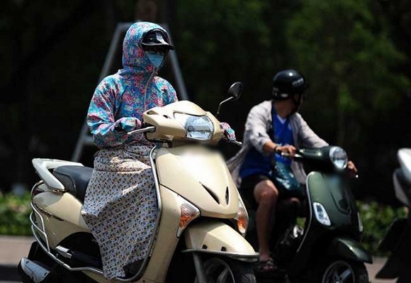  
Hình ảnh một người mặc áo và váy chống nắng di chuyển trên đường. (Ảnh: Ngôi Sao)