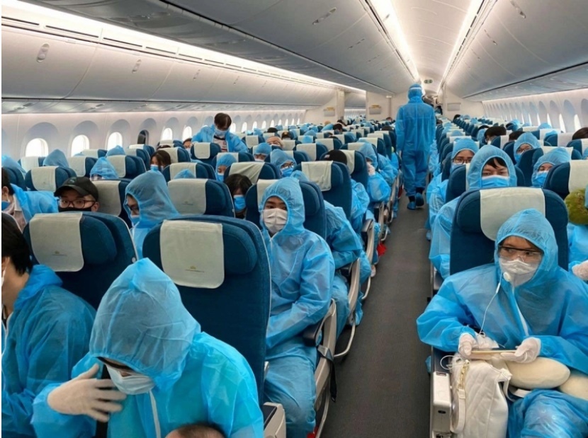  
Mọi người được trang bị đồ bảo hộ trên chuyến bay trở về Việt Nam (Ảnh: Tuổi trẻ Thủ đô)