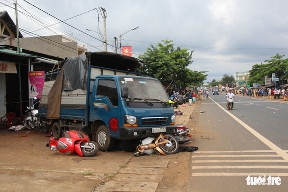 Xe máy của người mua hàng bị cuốn vào xe tải (Ảnh: Tuổi Trẻ Online)