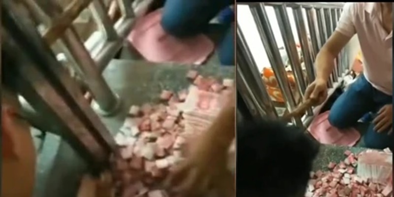  
Hai bố con ông Đường đang đập tay vịn cầu thang để lấy tiền. (Ảnh chụp từ clip)