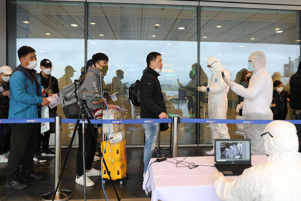  
Nhân viên y tế kiểm tra sức khỏe cho hành khách tại sân bay (Ảnh: Sức khỏe)