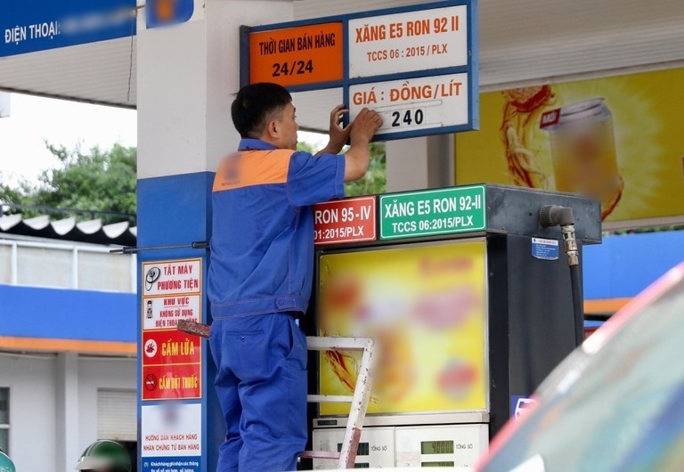  
Một nhân viên dán mức giá mới sau khi giá xăng được điều chỉnh (Ảnh: Thanh niên)