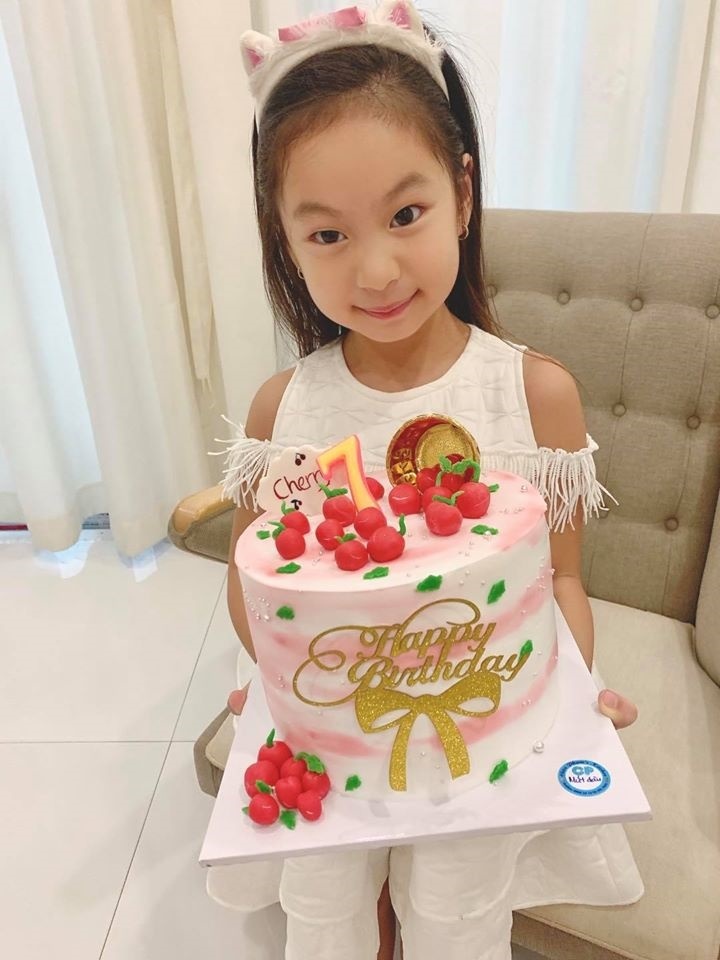  
Cô bé tạo dáng với biểu cảm đáng yêu bên cạnh bánh sinh nhật. (Ảnh: FBNV)
