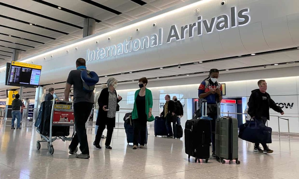  
Mọi người đeo khẩu trang khi tới sân bay ở Anh (Ảnh: The Guardian)