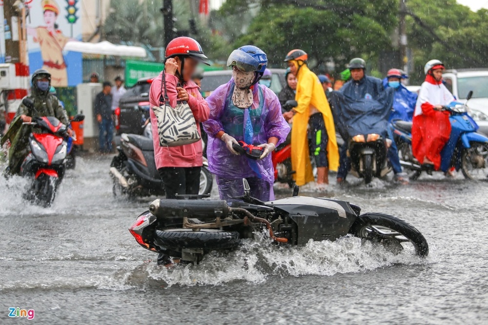  
Hai người khác cũng bị đổ xe ra đường vì đi trong mưa lớn qua đoạn đường ngập (Ảnh: Zing)