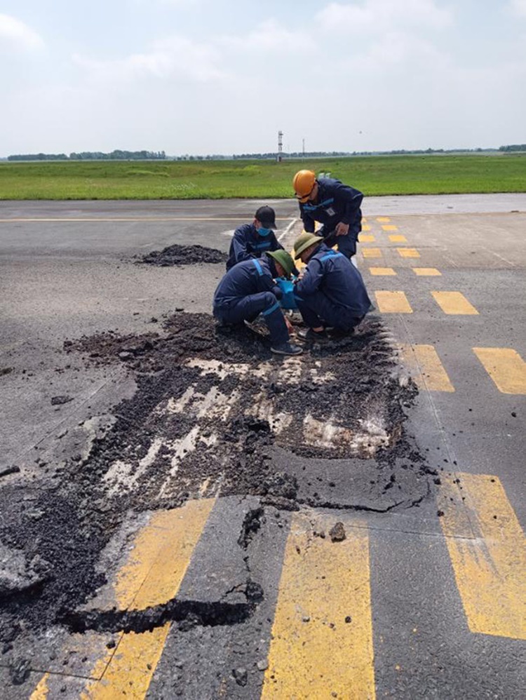  
Nhân viên đang tiến hành sửa chữa các vị trí bị hư hỏng trên đường băng tại sân bay Nội Bài. (Ảnh: Tuổi Trẻ)