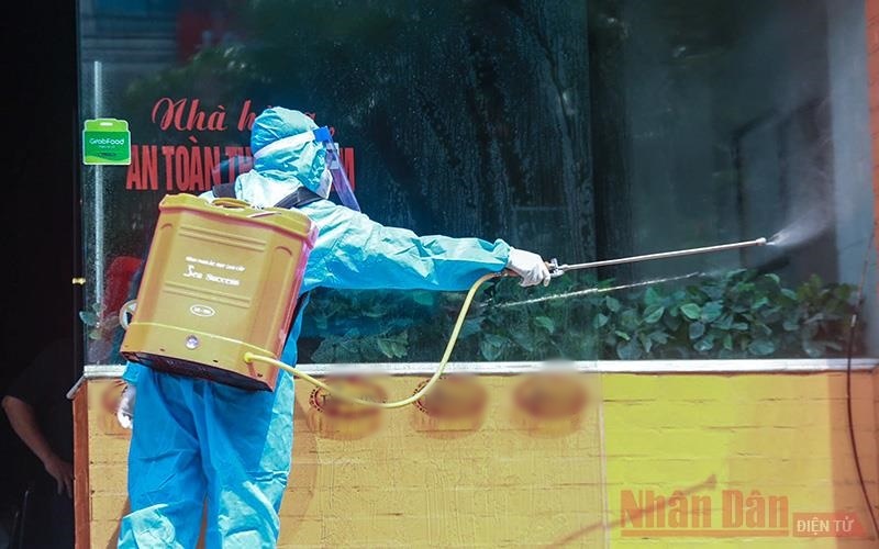  
Lực lượng chức năng phun khử trùng khu vực bệnh nhân mắc Covid-19 ở Hà Nội làm việc (Ảnh: Nhân Dân)