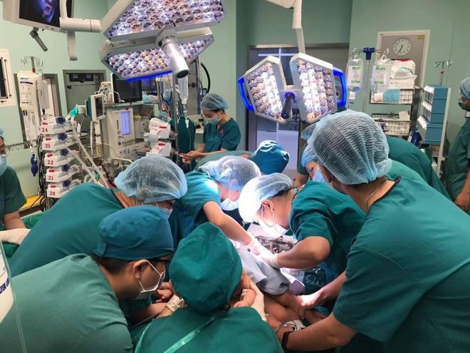  
Ekip thực hiện ca phẫu thuật cho 2 bé song sinh dính liền (Ảnh: VTC News)