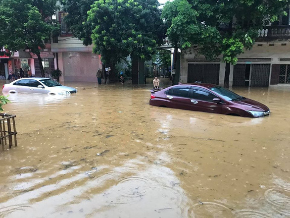  
Mưa lớn gây ngập trên một tuyến đường ở Lào Cai, ô tô chìm trong biển nước. (Ảnh: Tuổi Trẻ)
